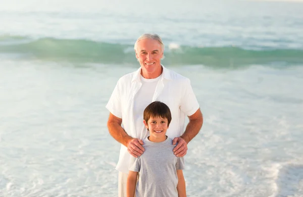 Grootvader en zijn kleinzoon op het strand — Stockfoto