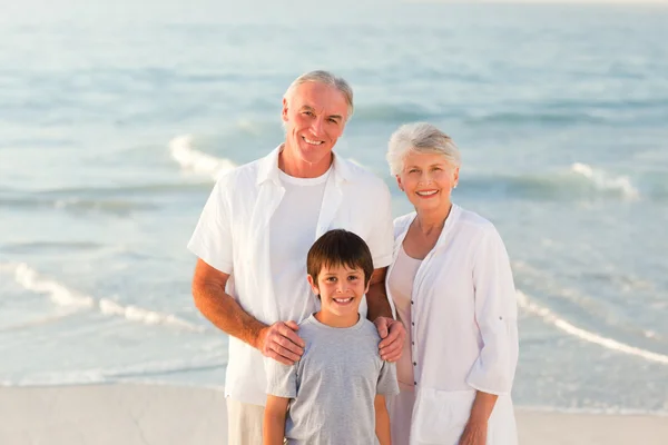 Бабушка и дедушка с внуком на пляже — стоковое фото