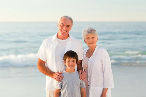 Бабушка и дедушка с внуком на пляже — стоковое фото