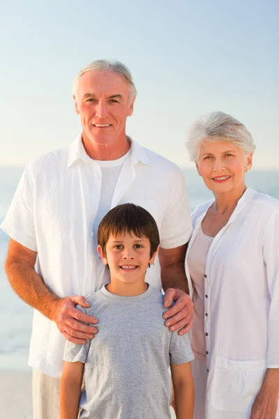 Großeltern mit Enkel am Strand — Stockfoto