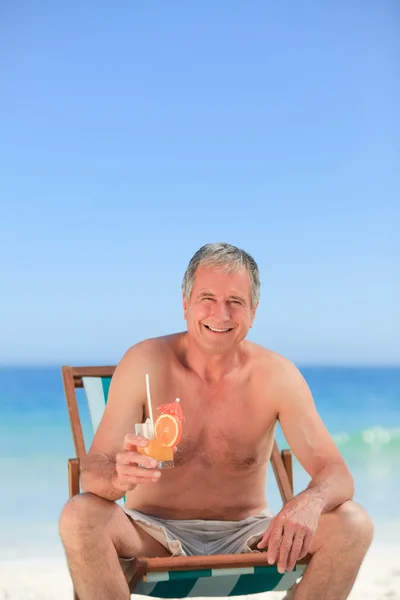 高级男人在海滩上喝一杯鸡尾酒 — 图库照片
