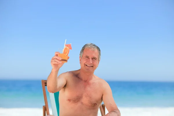 高级男人在海滩上喝一杯鸡尾酒 — 图库照片