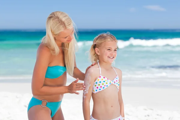 Mor tillämpa sun cream på dotterns rygg — Stockfoto