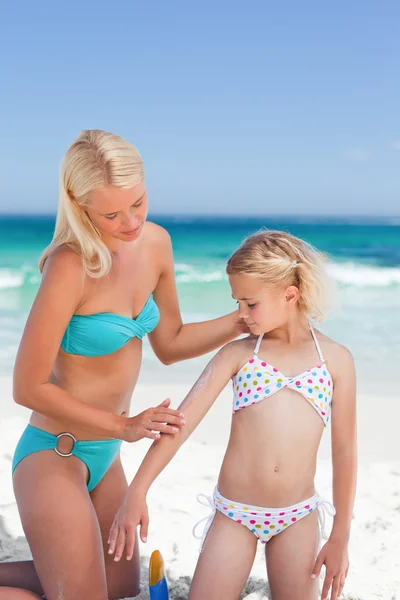 Mor tillämpa sun cream på dotterns rygg — Stockfoto