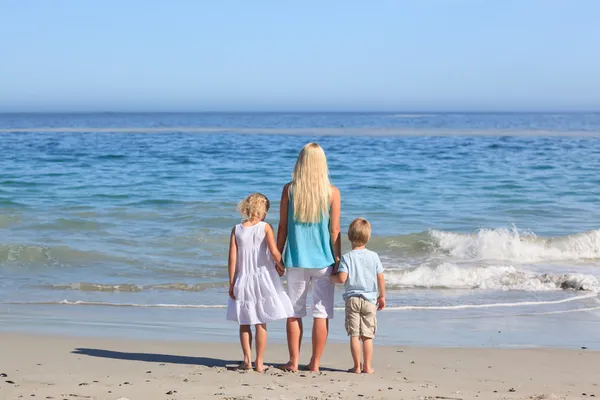 Familia alegre caminando por la playa — Foto de Stock