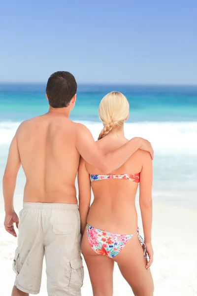 Женщина обнимает своего мужа на пляже — стоковое фото