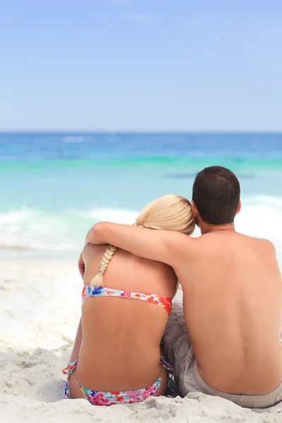 Man kramar sin flickvän medan de tittar på havet — Stockfoto