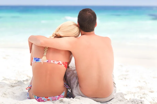 Man kramar sin flickvän medan de tittar på havet — Stockfoto