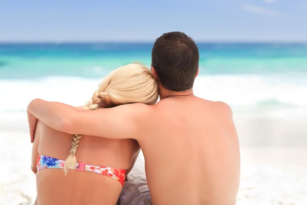 男人抱着他的女朋友，虽然他们正在看海 — 图库照片