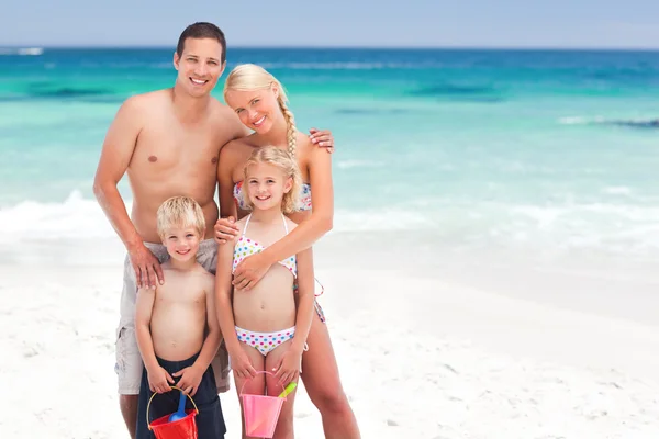 Família radiante na praia — Fotografia de Stock