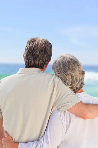 Старша пара дивиться на море — стокове фото