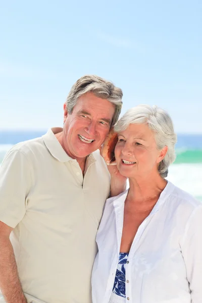 Pensiunan pasangan mendengarkan shell mereka — Stok Foto