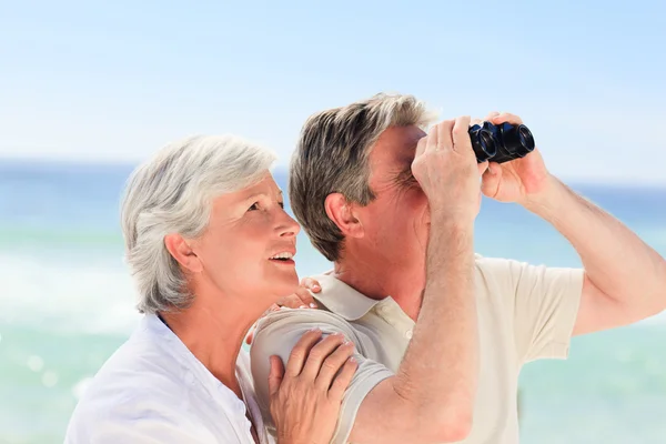 Äldre par fågelskådning på stranden — Stockfoto