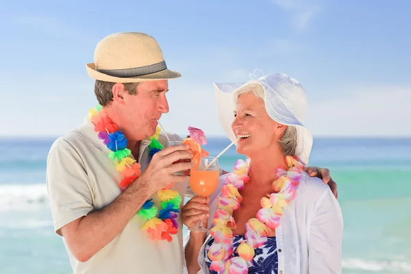高齢者のカップル、ビーチでのカクテルを飲み — ストック写真
