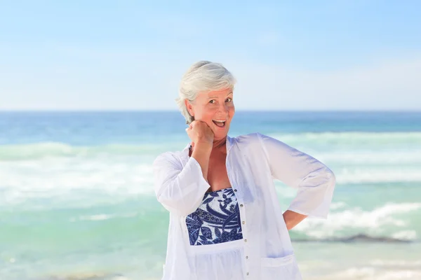 Glad pensionerad kvinna på stranden — Stockfoto