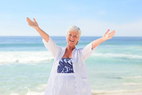 Gelukkig gepensioneerde vrouw op het strand — Stockfoto