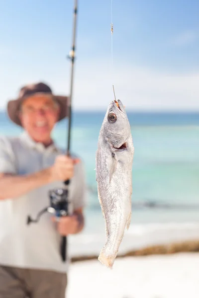 Мужчина рыбачит на пляже — стоковое фото