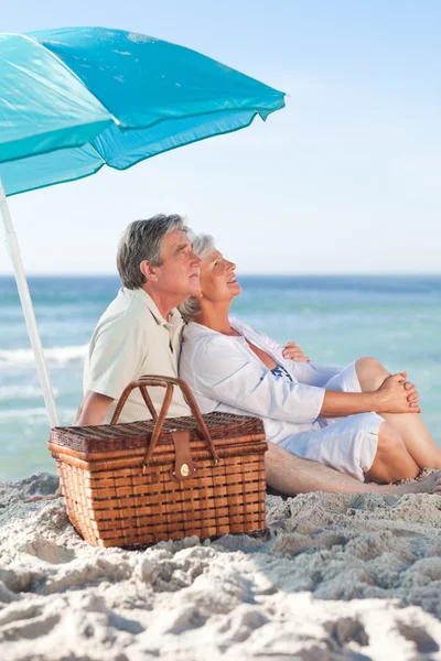 Idős házaspár picniking a strandon — Stock Fotó