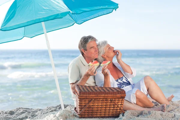 Bejaarde echtpaar picniking op het strand — Stockfoto