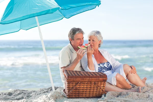 Bejaarde echtpaar picniking op het strand — Stockfoto