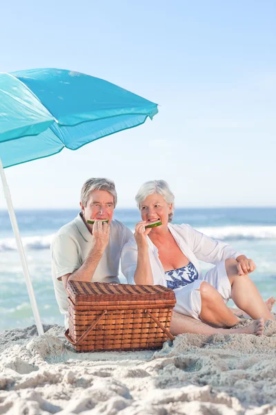 Pareja de ancianos haciendo picnic en la playa — Foto de Stock