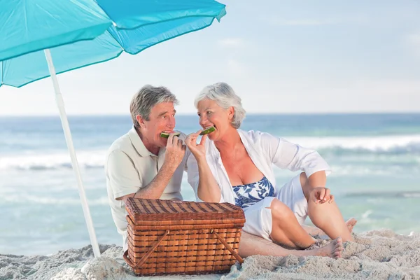Idosos casal piquenique na praia — Fotografia de Stock