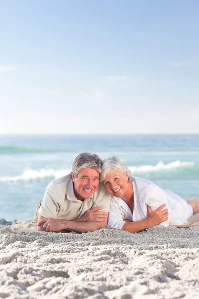 Ouder paar liggen op het strand — Stockfoto