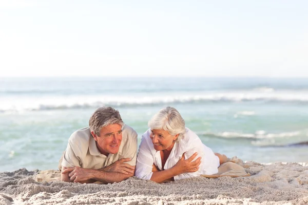 Зрелая пара, лежащая на пляже — стоковое фото