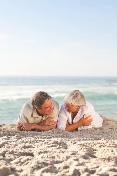 Ältere Paare legen sich auf den Strand — Stockfoto