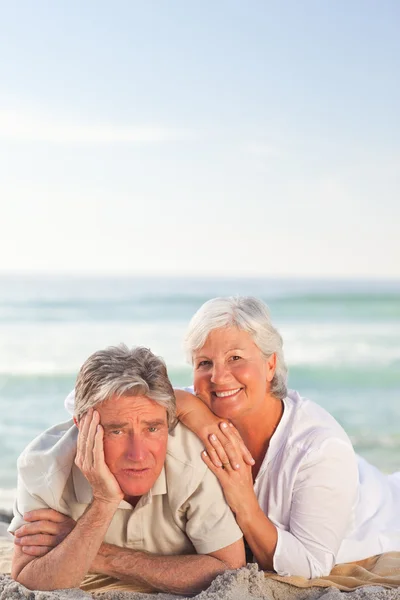 Bejaarde echtpaar liggen op het strand — Stockfoto