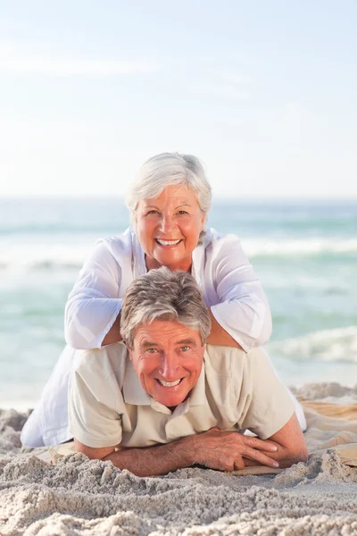 高齢者のカップル、ビーチに横たわって — ストック写真