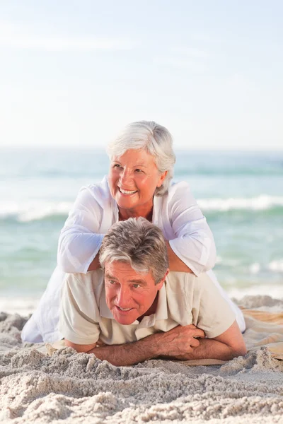 Старшая пара лежит на пляже — стоковое фото