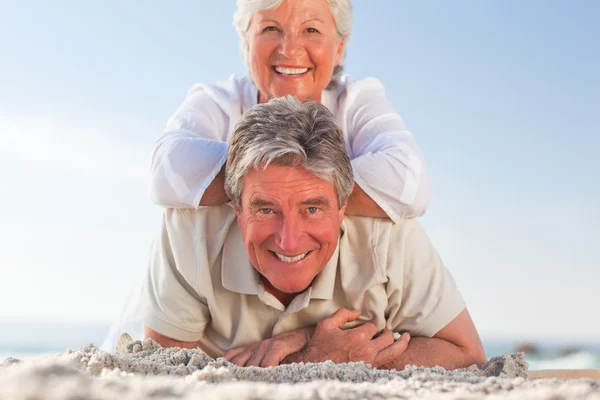 Seniorenpaar legt sich auf den Strand — Stockfoto