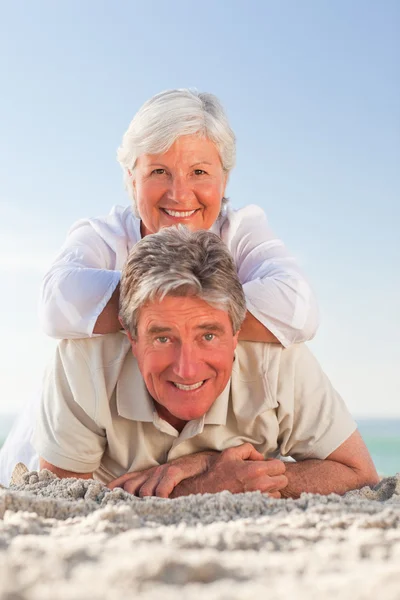 Senior koppel liggen op het strand — Stockfoto