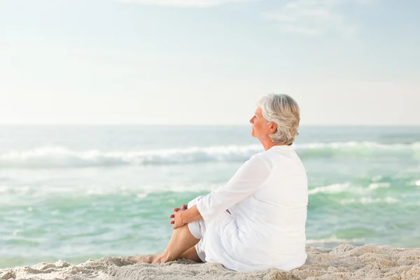 Woman who is sitting on the beach — Stock Photo, Image