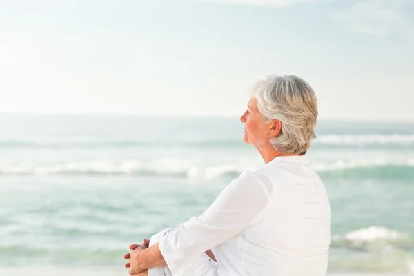 Frau, die am Strand sitzt — Stockfoto