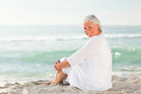 Kobieta, która siedzi na plaży — Zdjęcie stockowe