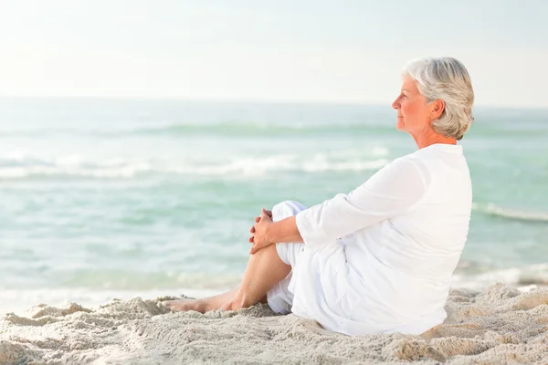 Woman who is sitting on the beach — Stock Photo, Image