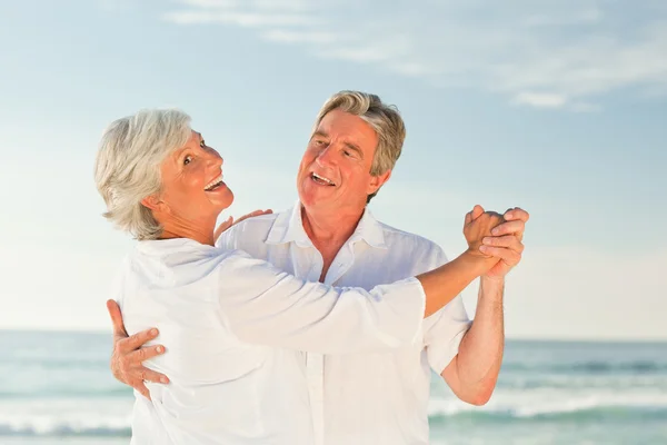 Зрелая пара танцует на пляже — стоковое фото