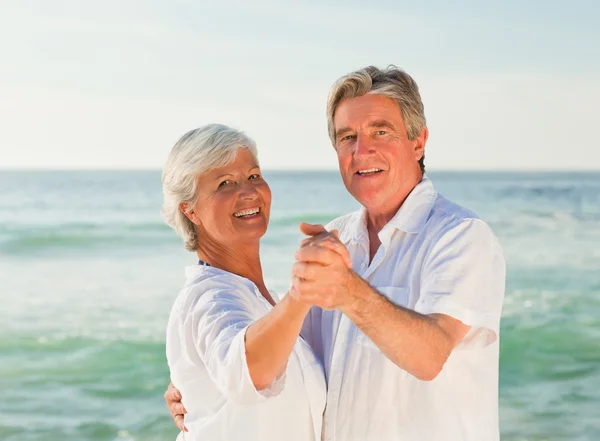 Ouder paar dansen op het strand — Stockfoto
