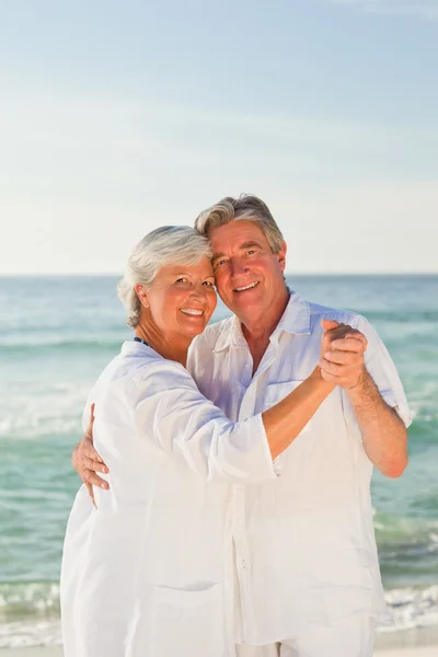 На пенсії пара танцює на пляжі — стокове фото