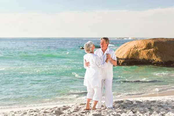 На пенсії пара танцює на пляжі — стокове фото
