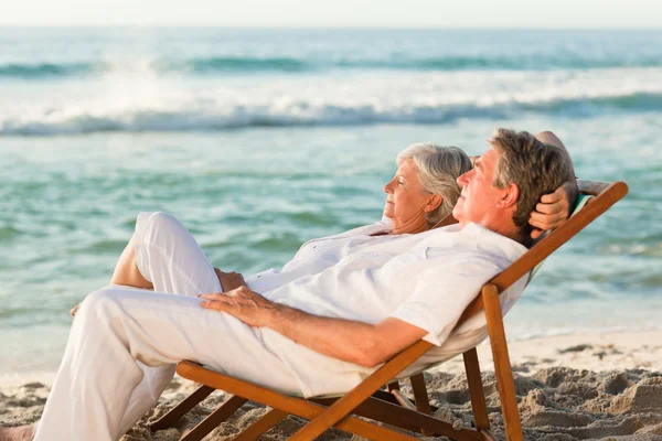 Elderly couple relaxing in their deck chairs — Stock Photo, Image