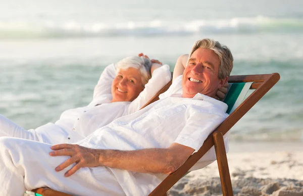 Äldre par kopplar av i sina solstolar — Stockfoto