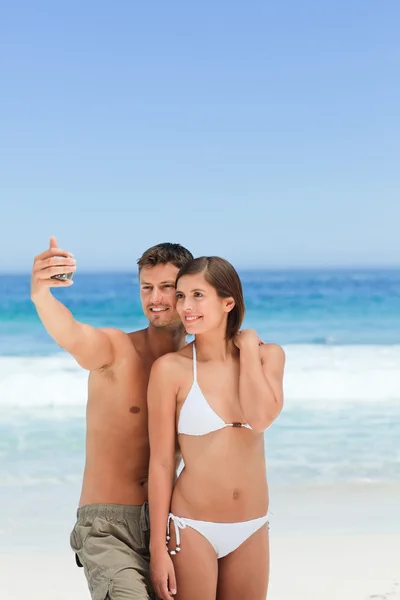 Los amantes con su cámara en la playa — Foto de Stock