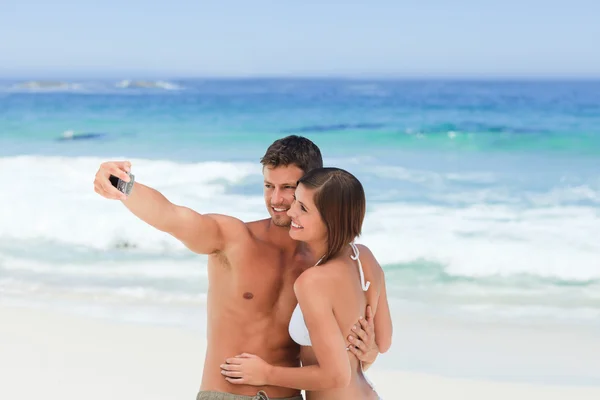 Los amantes con su cámara en la playa — Foto de Stock