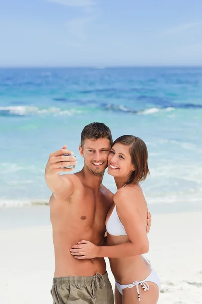 Kochankowie z ich kamery na plaży — Zdjęcie stockowe