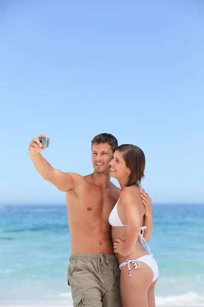 Älskare med sin kamera på stranden — Stockfoto