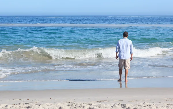 Человек, идущий по пляжу — стоковое фото