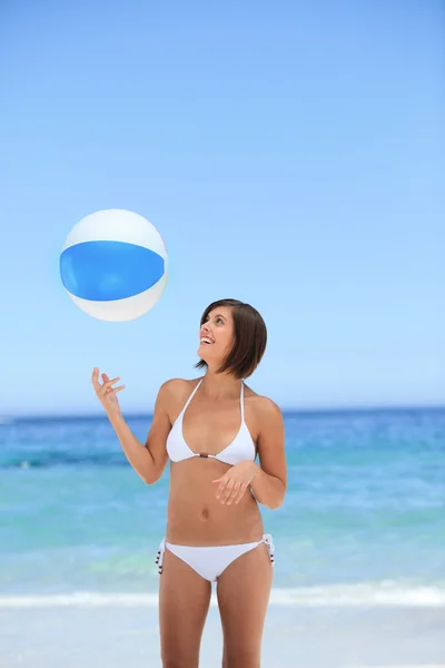 Härlig kvinna med sin boll på stranden — Stockfoto